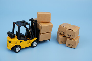 Naklejka premium Forklift truck and shipping carton boxes on blue background. Industry and cargo concept.