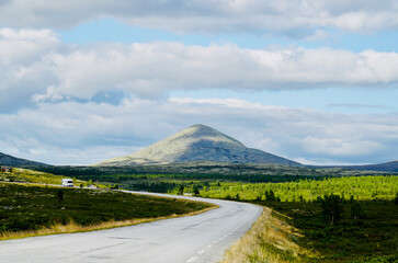 Fototapeta premium Open road with a view of mountains along the scenic Rondevegen over Venabygdsfjellet, Norwegian Scenic Route Rondane.