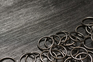 Metal rings for leather craft on the wooden black background with copy space. Leather furniture....