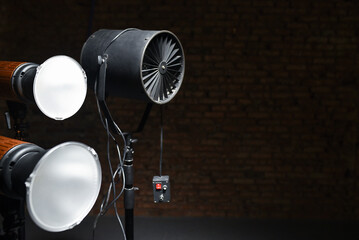 Photostudio led constant light sources and axial fan on the brick wall background. Photo studio equipment.