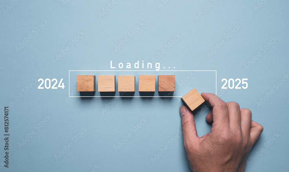 Wall mural hand assemble wooden block cube to update technology downloading tool bar status from 2024 to 2025 ,