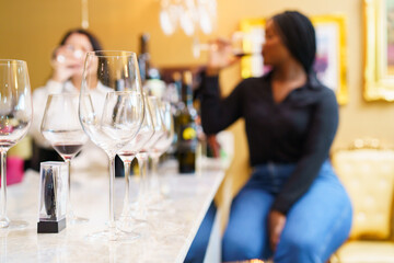 Group of women enjoy testing wine together at the restaurant.