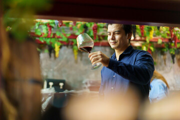 Hispanic man enjoy testing a wine at the wine restaurant.