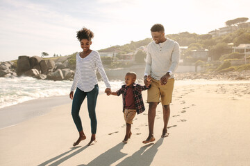 Family with son walking along the beach