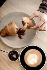 hand top view with croissant and coffee with milk