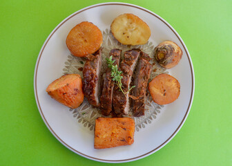 A baked dinner featuring sliced leg of lamb with vegetables and lemon thyme.
