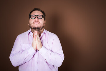 Anger and aggression. Upset fat man posing on a brown background.