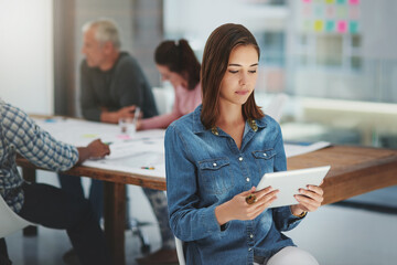 Woman, creative and research with tablet in meeting for data, development or agenda at office....