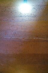 Background of the rammed earth wall with light bulb.