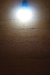 Background of the rammed earth wall with light bulb.
