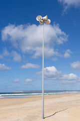 Beach megaphone speaker siren on a sunny day with bright blue sky