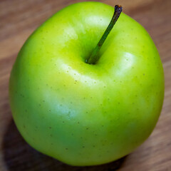 The wooden surface beneath the apple adds a rustic, organic feel.