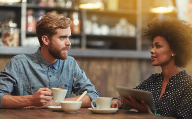 Chat, man and woman in cafe with tablet, social media and relax for networking connection at table. Date, conversation and interracial couple in coffee shop with online digital app, drink and talking