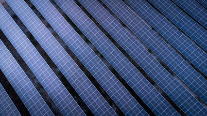 Aerial view of solar energy panels in the solar farm business of green energy industrial by a drone during the evening with twilightlight.