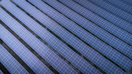 Aerial view of solar energy panels in the solar farm business of green energy industrial by a drone during the evening with twilightlight.