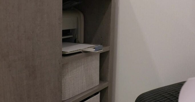 man using printer, male hand put papers on multifunctional copier .