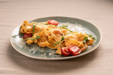 Italian Fettuccine pasta with shrimp, tomatoes and herbs on plate at table.