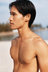 Muscular Asian Athlete Enjoying a Sunset Beach Run: Exuding Strength, Power, and Freedom