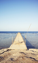Old wooden pier at the sea, color toning applied.