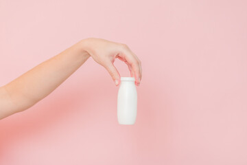 White bottle of probiotic yogurt for digestive system in hand. Dietary supplements for stomach