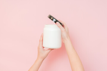 Hands hold white bottle with nourishing mask for applying to hair or skin. Beauty and spa, cosmetics
