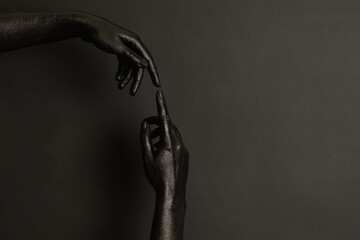 Woman's hands with black paint on her skin on dark background. High Fashion art concept