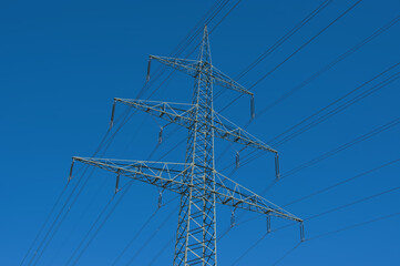 Strommast / Hochspannungsleitung / Hochspannungsmast (Überlandleitung) vor einem blauen Himmel -...