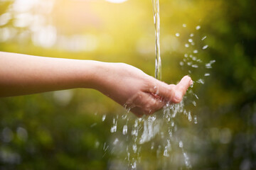 Hand, hygiene or water with splash or stream for awareness, resources on earth in park. Closeup,...