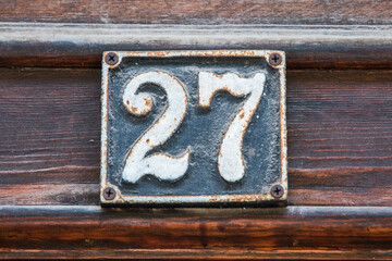 Old retro weathered cast iron plate with number 27