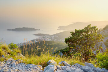 Aerial view of Budva Riviera from Fort Kosmach at sunset. Old fortress ruins is located in...