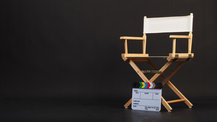 White director chair with clapper board on black background.