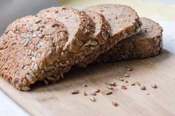 Whole wheat bread with sunflower seeds on a cutting board.