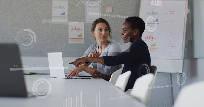 Image of graphs, loading bars and circles, diverse female coworkers discussing reports on laptop