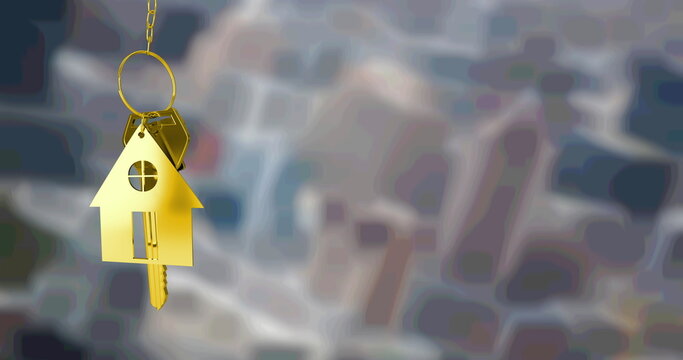 Image of gold house key fob and key, hanging in front of blurred city buildings
