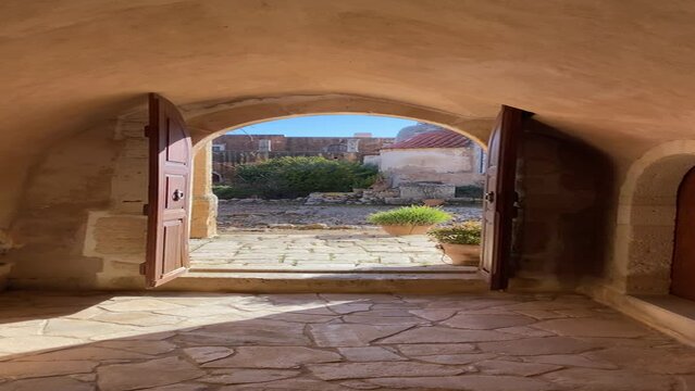 Arcadi church of transfiguration Crete, Greece. Ancient monastery, walking video, vertical, old European architecture, medieval mood, sunset, historic point entrance to the castle