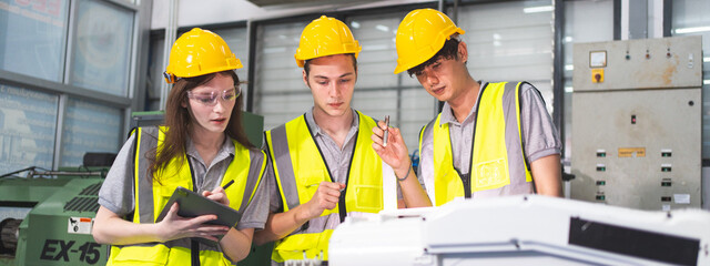 A Group of engineer are examining machine robot arm with smart tablet. Installation indoor...