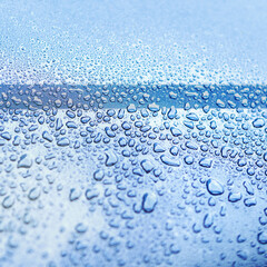 Water, drops and wet on blue surface in nature for wallpaper, background and textures in environment. Rain, window and liquid on screen for cleaning, glass and close up of smooth exterior in shower