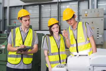 A Group of engineer are examining machine robot arm with smart tablet. Installation indoor industrial factory. Technician coworker check for repair maintenance electronic operation with remote system