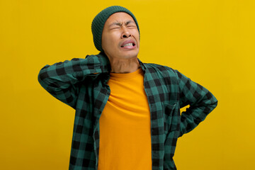 Asian man massages his neck and touches his back, relieving muscle pain caused by overwork,...