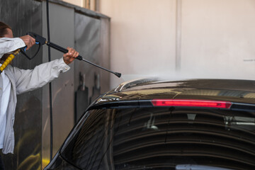 man washes his car at the car wash