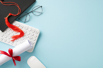 A neatly organized desktop featuring a graduation cap, diploma scroll tied with a red ribbon,...