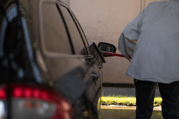 man washes his car at the car wash