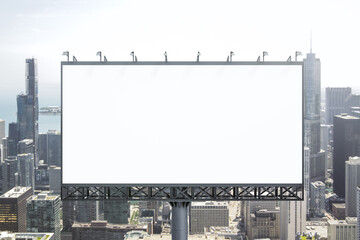 Obraz premium Blank white billboard on city buildings background at daytime, front view. Mockup, advertising concept