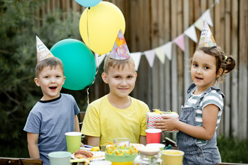 Cute funny nine year old boy celebrating his birthday with family or friends with homemade baked...
