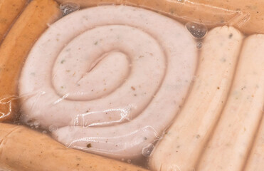 Sausages in vacuum plastic packaging texture background. Vacuum transparent packaging with fresh...
