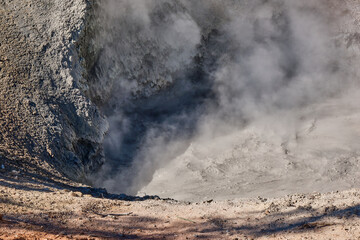 Mud volcano in the morning hours of early fall with steam and bubbles