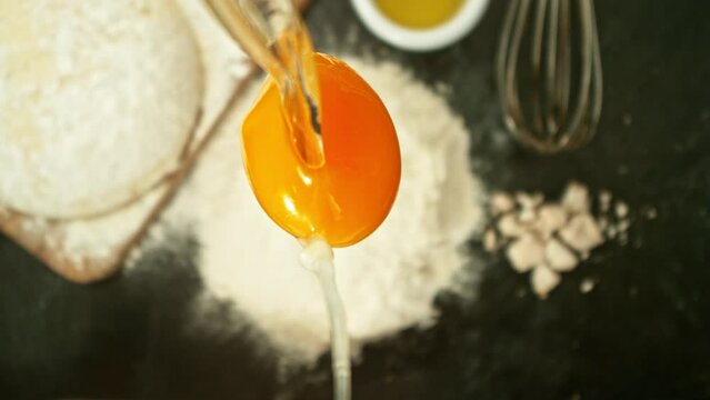 Super Slow Motion of Falling Raw Egg into Flour. Filmed on High Speed Cinema Camera, 1000fps, Placed on High Speed Cine Bot. Camera in Motion, Following Objects. Cooking Concept.