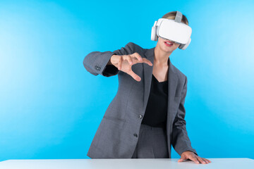 Project manager wearing VR headset and standing while holding innovation technology hologram. Skilled businesswoman connect with visual reality world while looking at data for investment. Contraption.