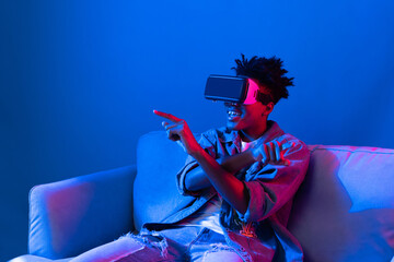 Young African American looking VR enjoy watching fantastic 3D pointing interesting object...