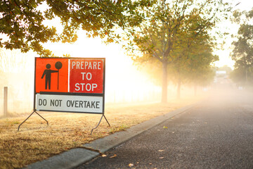 Warning sign for cars, vehicles. Prepare to stop, due to cycling event. Used at bicycle race in Australia. Early morning, misty, fog.